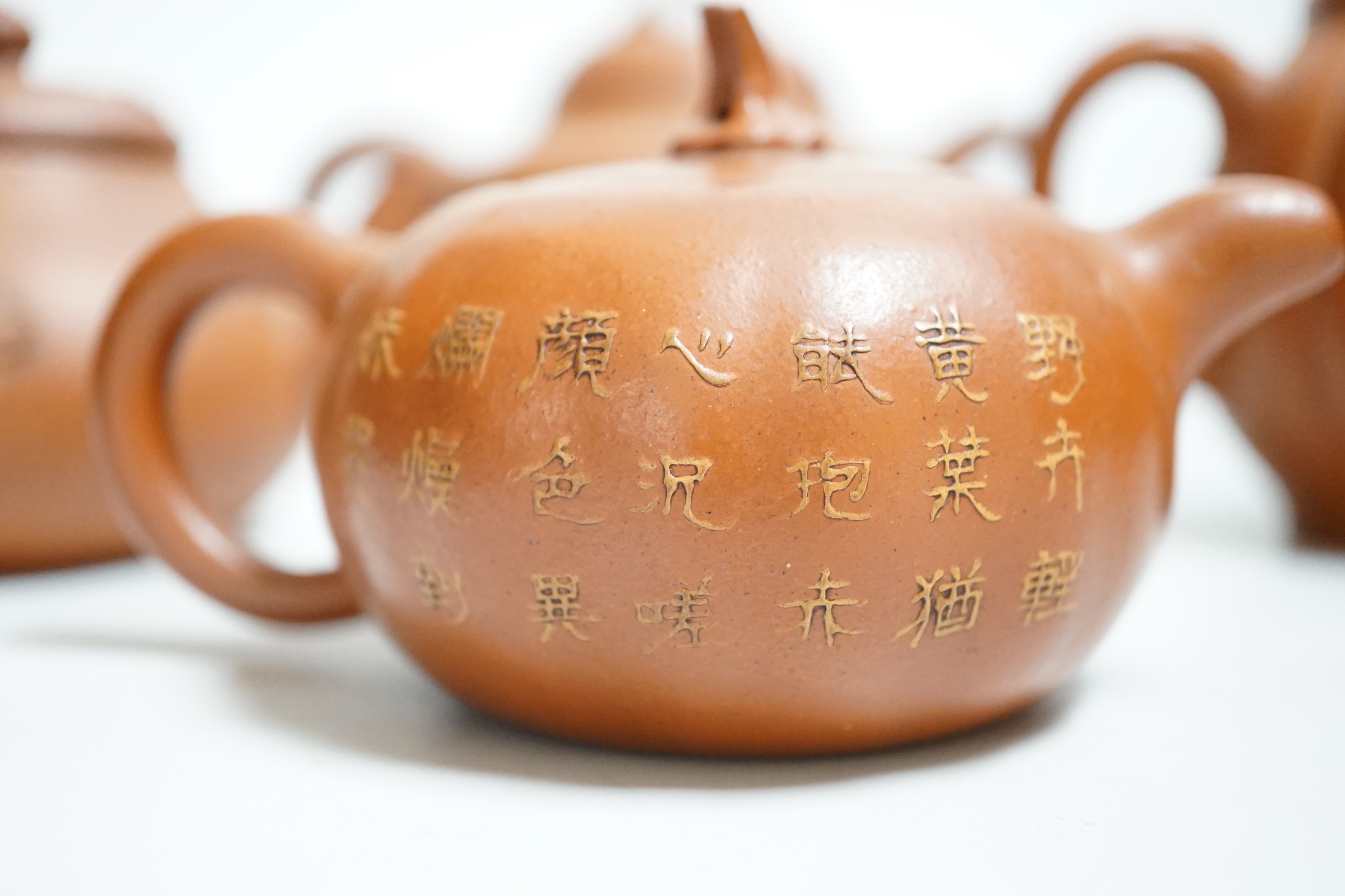 Four Chinese Yixing teapots, one slip decorated with a landscape